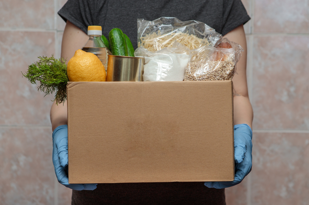 A person holding a box of food in their hands.