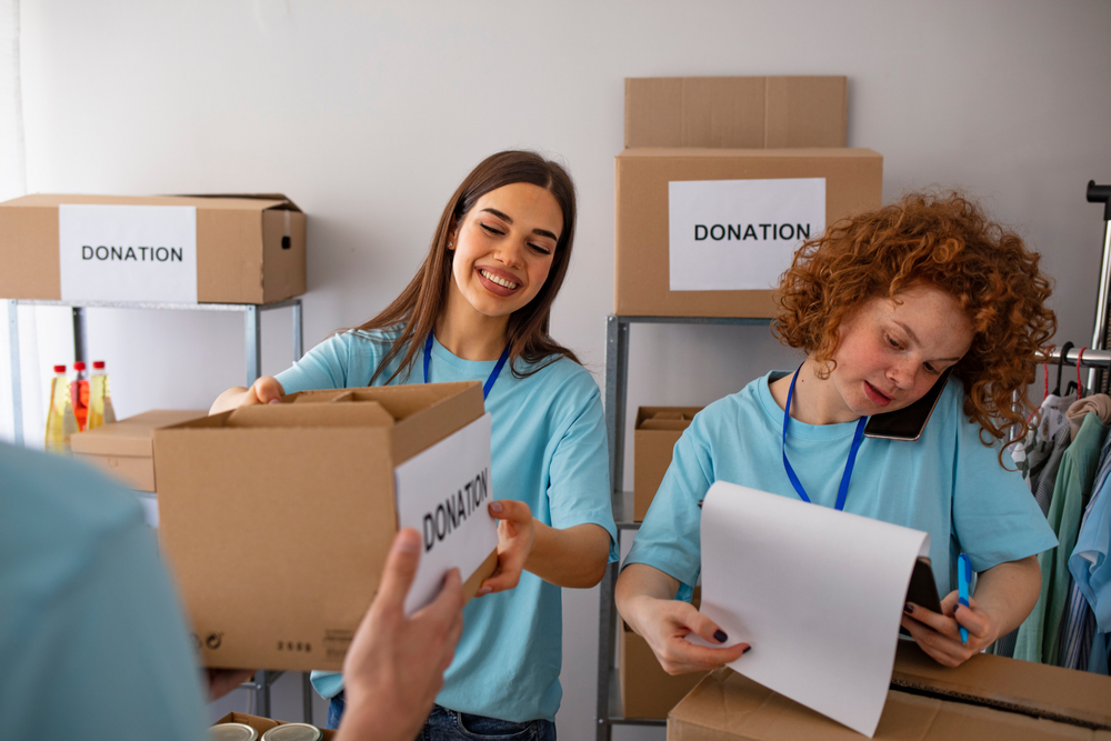 Two women are packing boxes for a donation.