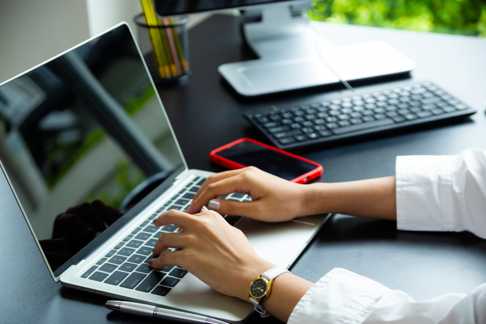 A person typing on a laptop computer.